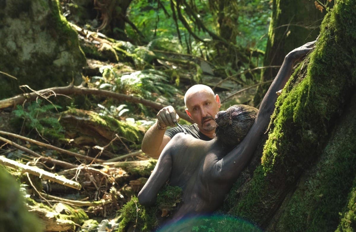 Archive photograph: Artist Filippo Ioco perfects the camouflaging paint on his model, so she becomes part of the tree she leans against. (📸 Zoë Ducklow/The Westshore)
